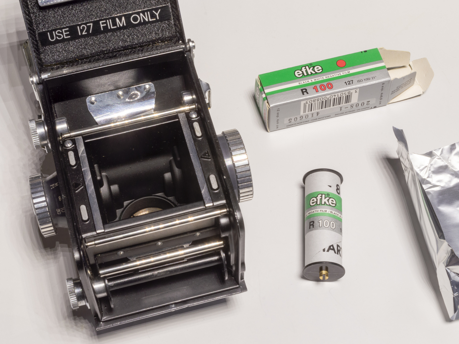 Farbbild (born-digital): Offene Kamera Yashica 44A mit dem Hinweis auf den Film-Typ 127 auf der Rückwand, daneben liegt eine Rolle Efke R 100 (Typ 127). (Foto: © Martin Frech, 12/2025)