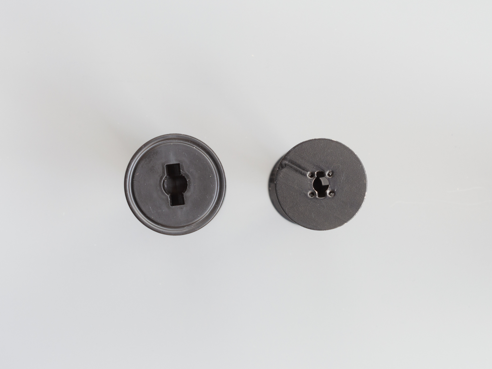 Zwei stehende Spulen für Mittelformat-Rollfilme in Aufsicht. Links eine Kunststoffspule für die Film-Typen 120/220, rechts eine Metallspule für den Film-Typ 620. (Foto © Martin Frech, 8/2025)