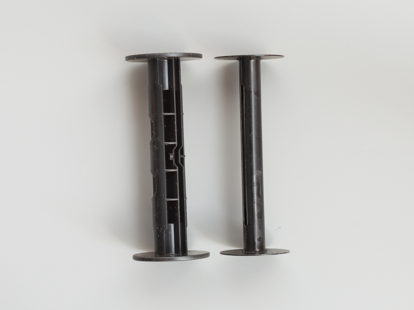Zwei liegende Spulen für Mittelformat-Rollfilme in Aufsicht. Links eine Kunststoffspule für die Film-Typen 120/220, rechts eine Metallspule für den Film-Typ 620. (Foto © Martin Frech, 8/2025)